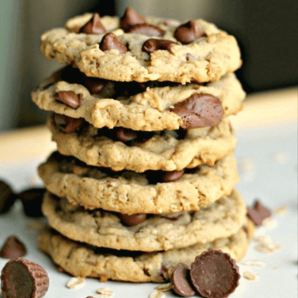 Freshly baked Reese's Chocolate Chip Cookies with gooey chocolate chips and a hidden Reese's cup surprise inside, displayed on a cooling rack